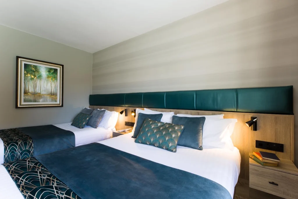 Twin beds in an elegant teal-accented hotel room